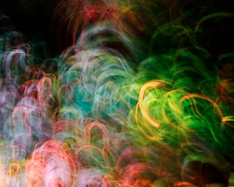 Vibrant swirling light trails in blue and yellow on a dark background, representing AI-generated motion and video output