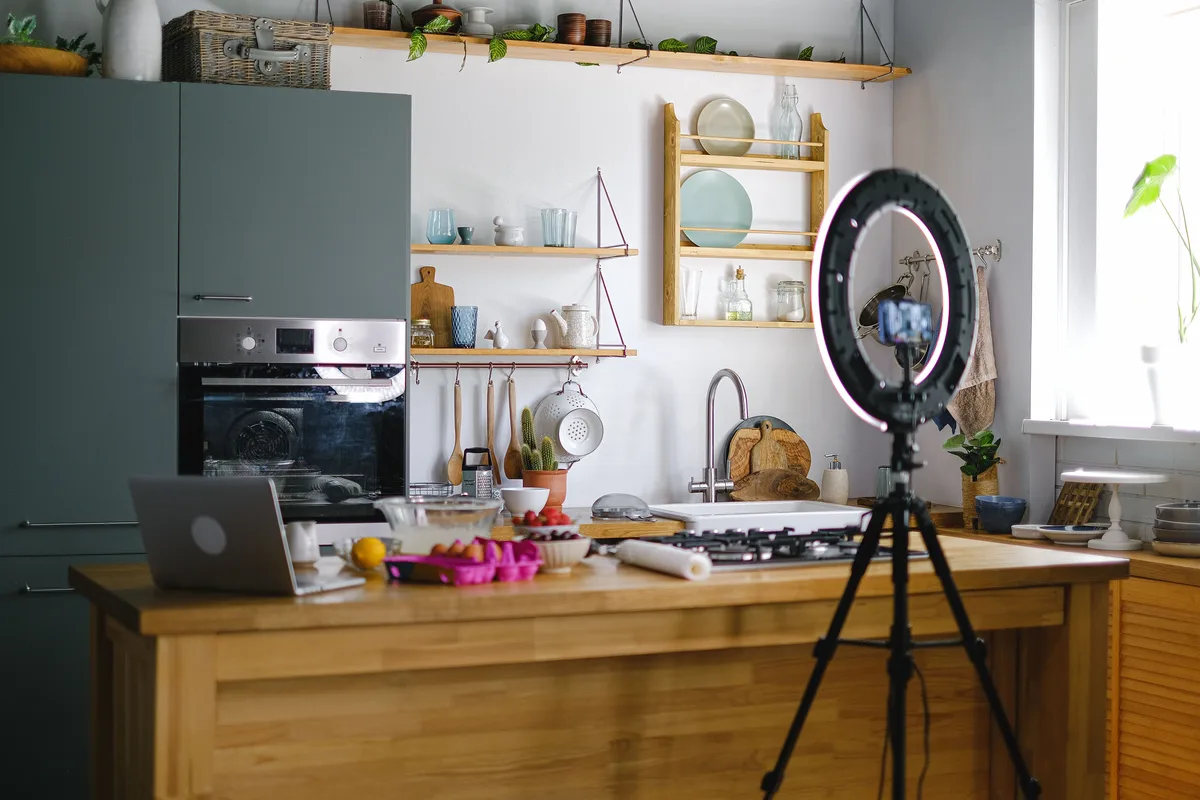 Ring light and tripod-mounted smartphone set up to record vertical video, a faceless creator’s content setup