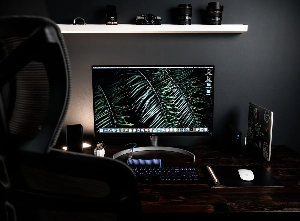 Dark minimal desk setup with a monitor displaying a screen recording interface