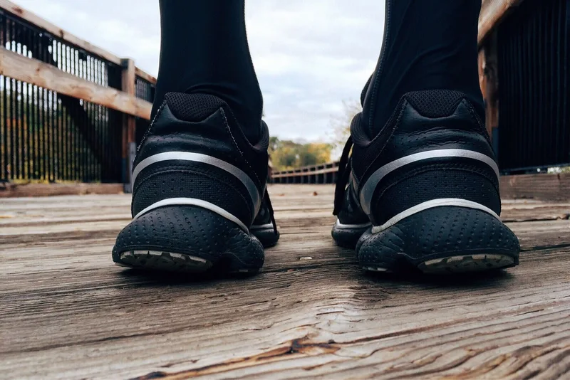 Close-up of athletic sneakers on a wooden bridge capturing a runner&rsquo;s exercise routine
