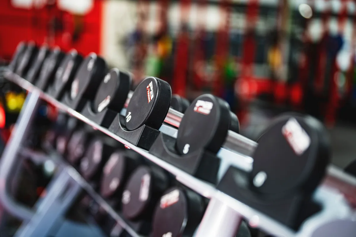 Close-up view of dumbbells in a modern gym setting, emphasizing fitness and training