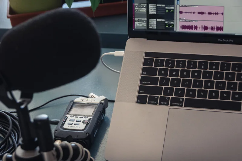 A microphone and laptop setup for audio recording representing the production tools for a faceless fun facts channel