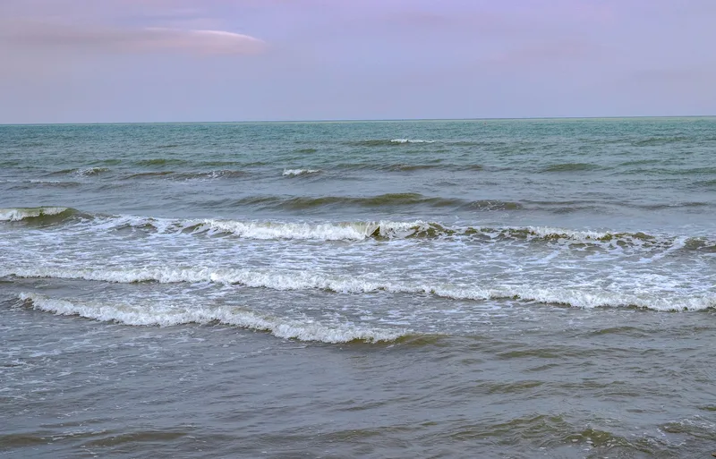 Tranquil ocean waves under a pastel sunset sky, capturing nature&rsquo;s soothing rhythm