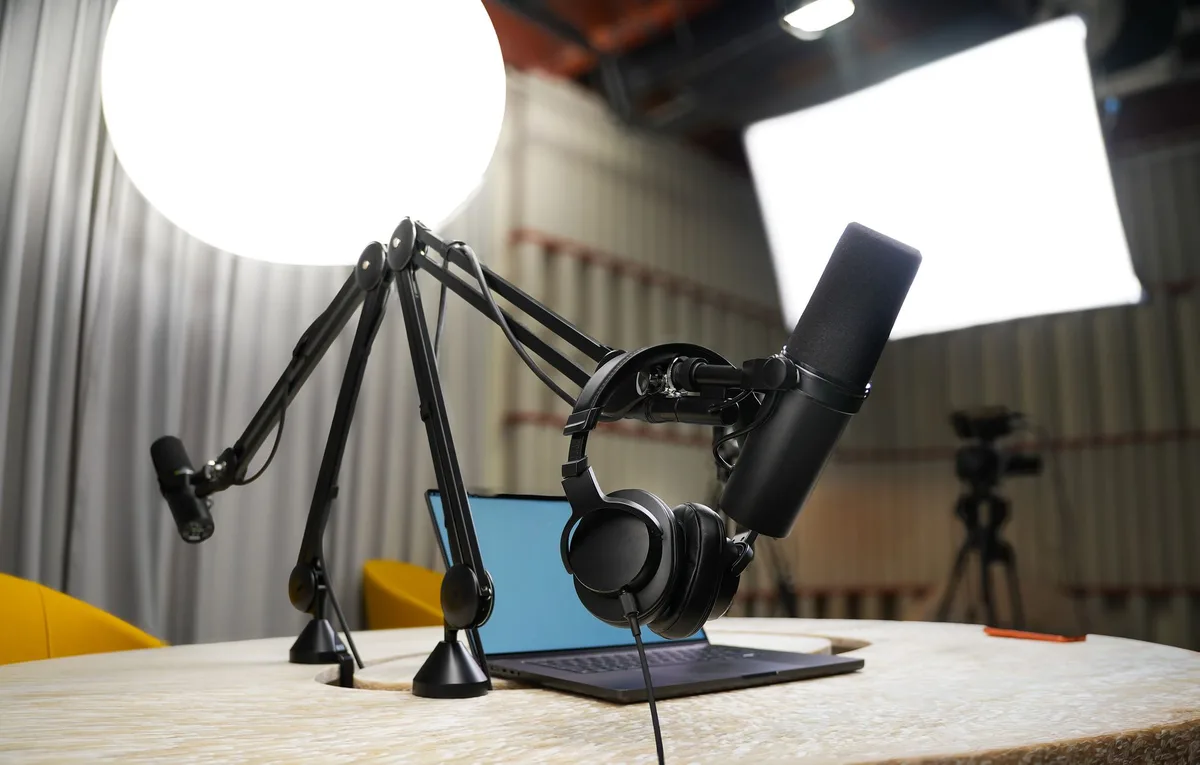 A modern podcast and broadcast studio with professional microphone, headphones, and studio lighting for recording