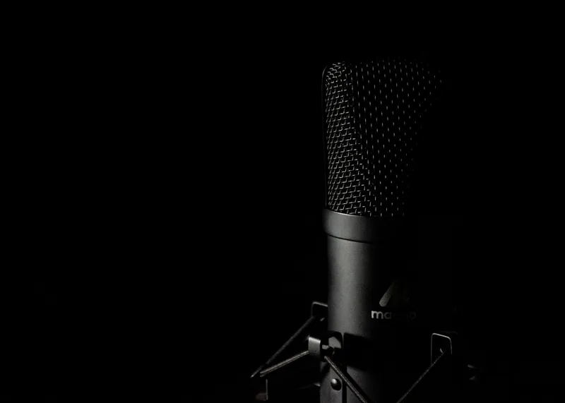 Professional podcast microphone setup with dark moody lighting for true crime narration recording