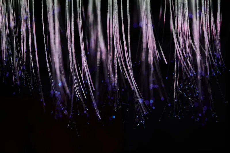 Abstract glowing blue fiber optic strands representing AI avatar technology and digital identity systems