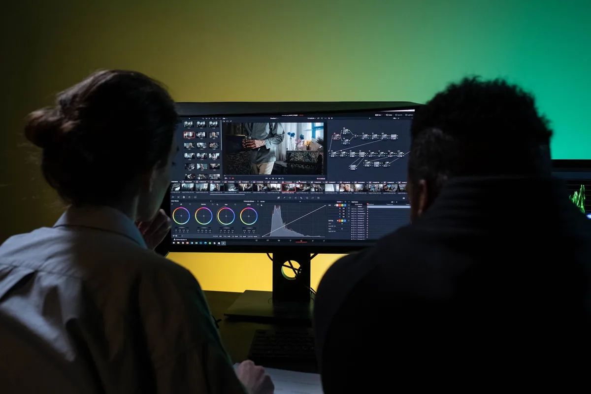 Video production team working at a dual-monitor editing setup