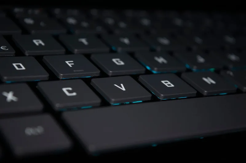 Close-up of a backlit laptop keyboard in a dark setting, representing the assembly step after AI clip generation