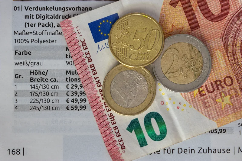 Euro coins and budget planning materials representing AI video tool cost comparison and pricing tradeoffs